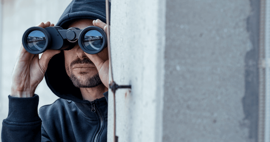 A criminal looking through binoculars
