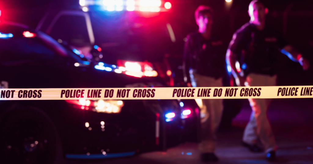 Yellow Crime Scene Tape with Police Officers in Background